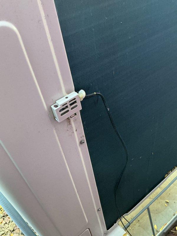 Responded to service call for heat pump with disconnected outdoor temperature sensor found on ground next to unit. Upon inspection, determined sensor had detached from its mounting location on exterior wall. Reinstalled sensor to proper position on building exterior adjacent to heat pump unit, secured mounting, and verified wire connection integrity. System restored to normal operation with sensor properly positioned for accurate temperature monitoring.
