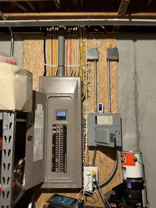 Provided on-site estimate for installation of 19kW EV charger requiring upgraded electrical service. Assessment determined need for Class 320 (400A) meter split to accommodate two separate 200A panels. Proposed installation plan includes running electrical wire from basement panel through unfinished utility room into garage, with conduit routing to customer's preferred charging location between garage stalls. Documented existing electrical panel configuration and available space for additional distribution equipment necessary to support 80-amp EV charging circuit.