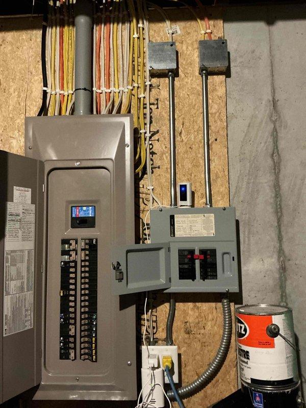 Provided on-site estimate for installation of 19kW EV charger requiring upgraded electrical service. Assessment determined need for Class 320 (400A) meter split to accommodate two separate 200A panels. Proposed installation plan includes running electrical wire from basement panel through unfinished utility room into garage, with conduit routing to customer's preferred charging location between garage stalls. Documented existing electrical panel configuration and available space for additional distribution equipment necessary to support 80-amp EV charging circuit.