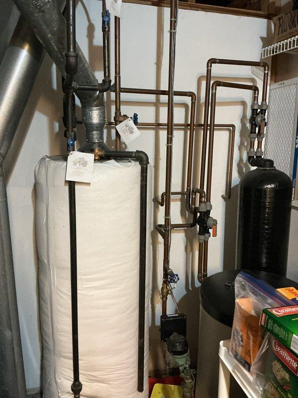 Responded to emergency call for water leak in utility room. Upon arrival, identified active leak in copper piping system near water heater and circulation pump assembly. Isolated affected section using existing shut-off valves to stop water flow. Repaired compromised pipe connection using appropriate brass fittings and secured all joints to prevent future leakage. Tested system for proper pressure and verified no additional leaks present throughout plumbing assembly before restoring water service.
