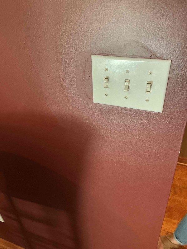 Completed installation of bathroom light fixtures and ceiling-mounted electrical fixture with visible wiring connections. Installed triple-gang switch plate with three toggle switches on interior wall, and added new electrical outlet in utility room as requested.