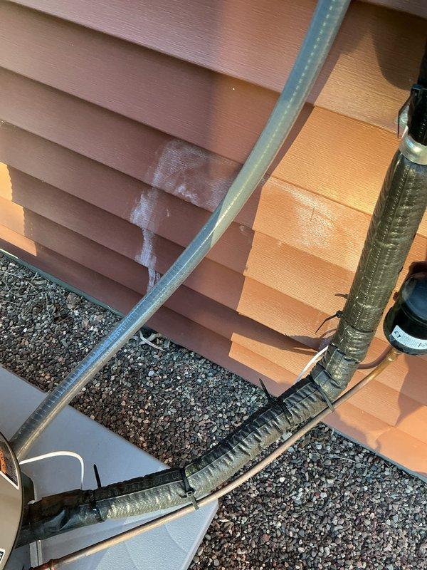 Responded to service call regarding white staining substance appearing on exterior siding adjacent to air conditioning unit. Conducted thorough inspection of AC system, refrigerant lines, and surrounding area to identify potential source of discharge. After comprehensive examination of HVAC equipment, rooftop installation, condensate drainage system, and building exterior, determined that the staining is not originating from the air conditioning unit or any related HVAC components. Suspect the substance is coming from behind the siding itself rather than from AC operation. Documented findings with photographs for record. No HVAC-related issues identified or repairs required at this time.