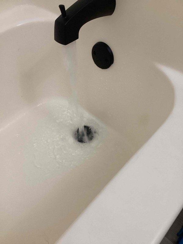 Responded to service call for whistling noise from shower faucet and slow-draining master bathroom tub. Upon inspection, identified significant hair accumulation in the tub drain line causing the drainage issue. Removed spring-loaded pop-up drain assembly and extracted substantial hair buildup from the drain line. Reassembled drain components and tested system to verify proper drainage was restored and all fixtures functioning correctly.