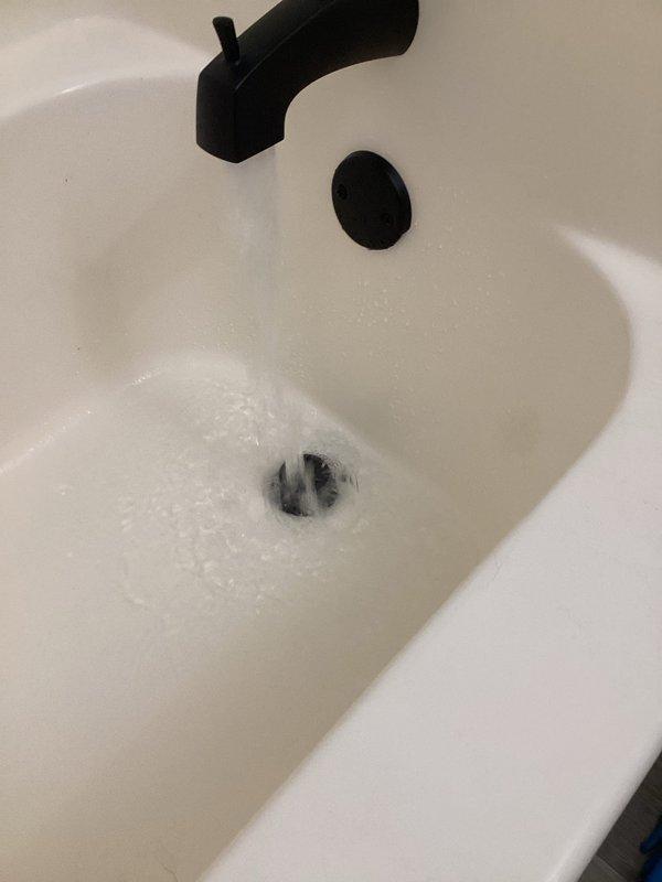 Responded to service call for whistling noise from shower faucet and slow-draining master bathroom tub. Upon inspection, identified significant hair accumulation in the tub drain line causing the drainage issue. Removed spring-loaded pop-up drain assembly and extracted substantial hair buildup from the drain line. Reassembled drain components and tested system to verify proper drainage was restored and all fixtures functioning correctly.