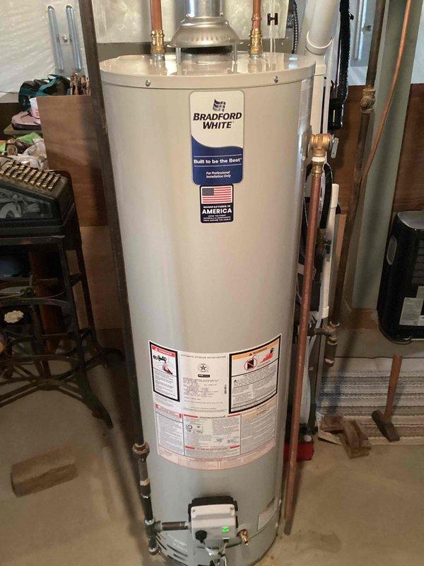 Removed existing 49-gallon natural gas atmospheric vent water heater after draining and disconnecting all connections. Installed new Bradford White 40-gallon natural gas atmospheric vent water heater with proper venting configuration. Added new drip leg to gas supply line and installed 1/2" ball valve on cold water inlet for isolation capability. Made all necessary water and gas connections, filled tank, and successfully lit pilot. Verified proper operation of all components and system functionality upon completion.