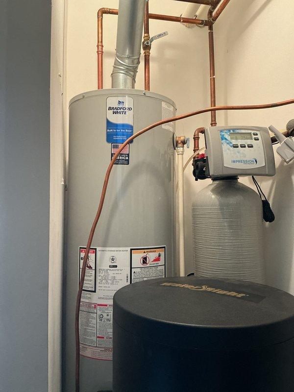 Completed installation of a 40-gallon Bradford White atmospheric natural gas water heater, model RG140T6N, with 40,000 BTU/hr input rating. Connected copper supply and discharge piping, installed galvanized vent pipe, and verified proper integration with existing water softener system. All connections tested and unit operational.