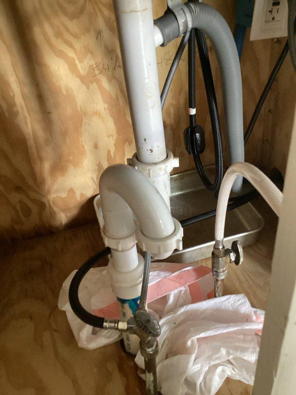 Responded to a reported kitchen faucet leak and upon inspection discovered the actual source was a leaking S-trap drain assembly beneath the kitchen sink. The leak was caused by a loose compression nut on the drain fitting. Tightened the compression nut to proper torque specifications and tested the drainage system to verify complete resolution of the leak with no further water seepage detected.