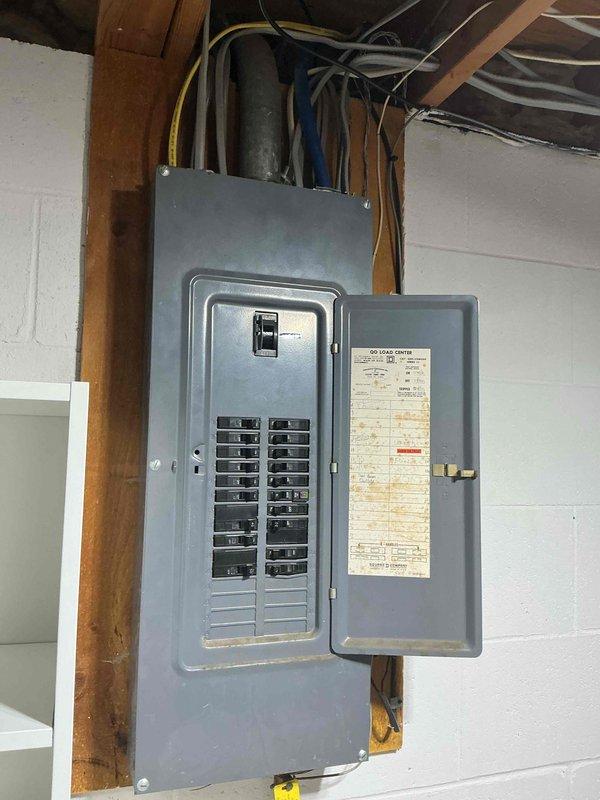 Performed on-site evaluation for wall-mounted electric vehicle charger installation in residential garage. Assessed existing electrical infrastructure including main breaker panel and unfinished basement area with exposed joists providing clear access to garage wall. Developed installation plan to junction new home run circuit in existing junction box located in garage, then run approximately 15 feet of conduit along garage wall to customer's preferred charger mounting location. Documented existing conditions including electrical panel configuration and available routing paths through basement ceiling space. Provided detailed estimate for complete EV charger installation including materials and labor.