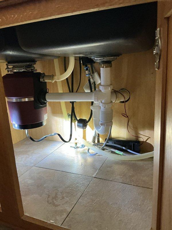 Installed a homeowner-supplied kitchen faucet and replaced the existing unit. Repiped the sink drain assembly, including the PVC tailpiece, tee, and P-trap connections to the garbage disposal and dishwasher drain line. Verified secure fittings and confirmed no leaks at the supply lines or drain connections.