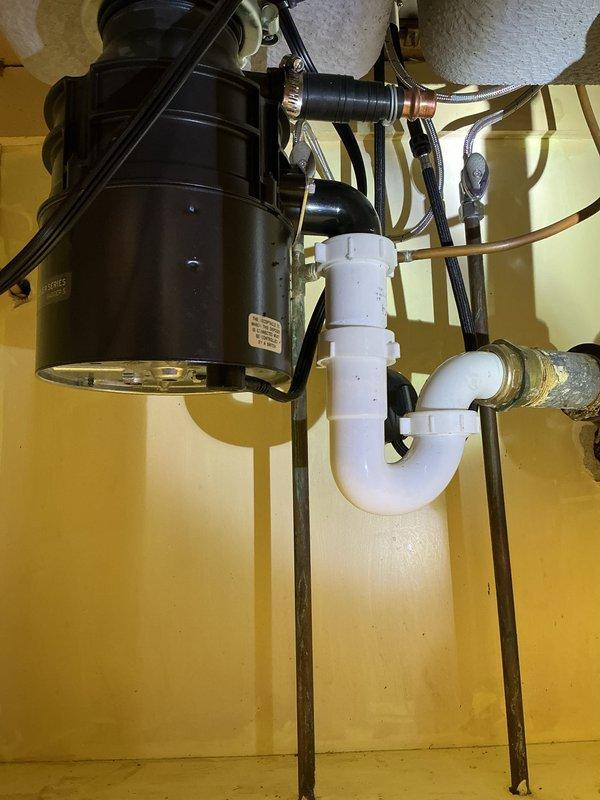 Removed the existing garbage disposal and installed a new Badger Five 1/2 HP unit, reconnecting it to the drain assembly with a rubber elbow fitting and hose clamp. Restored the electrical connection to the existing switched outlet and verified the P-trap connections were secure and the unit operated properly.