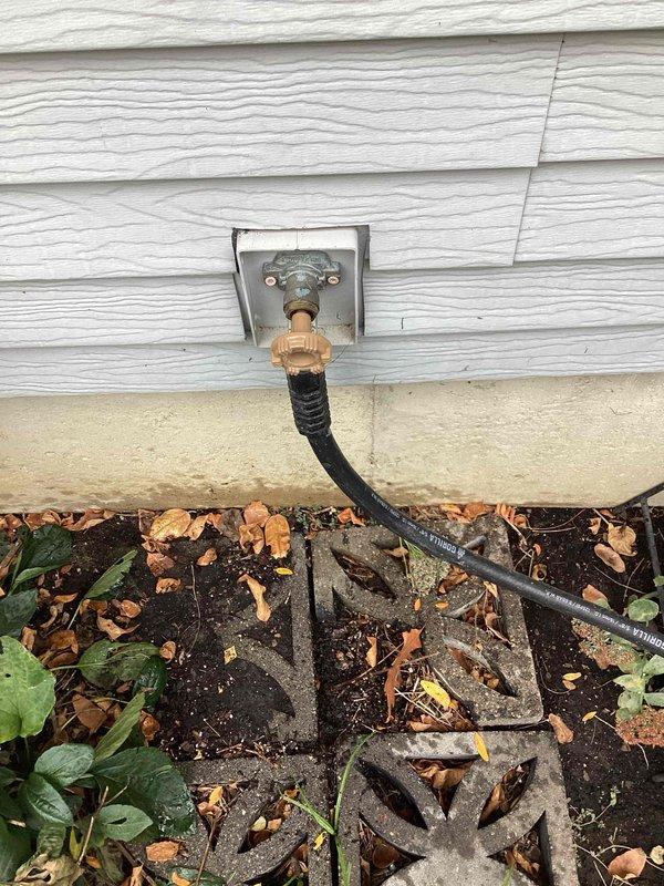 Diagnosed a leak at the exterior hose bib that occurred when a garden hose was connected and the valve was opened. Found a loose packing nut on the faucet stem and tightened it to restore a proper seal. Tested the spigot under pressure with the hose attached and confirmed it operates with no leakage.