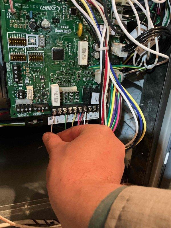Responded to a no-heat complaint on a Lennox gas furnace displaying multiple fault codes, with a thermostat error code also present following a recent humidifier installation. Inspection of the SureLight control board identified a loose thermostat wire at the W terminal, which was interrupting the heat call. Reseated and secured the W conductor to the terminal block, restoring proper low-voltage connection and normal heating operation.