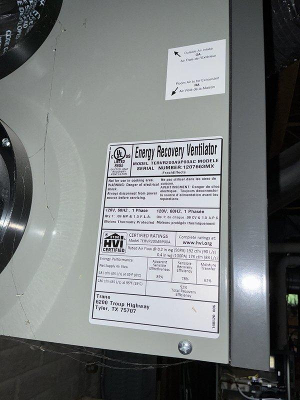 Completed comprehensive cooling system maintenance check on 2007 Trane air conditioning unit and performed inspection of associated HVAC equipment including Trane furnace model TUH2D120A9V5VAB and American Standard energy recovery ventilator model TERVR200A9P00AC. Inspected condenser coil assembly and heat exchanger components, noting age-appropriate oxidation and rust staining along coil-to-panel seams with visible wear on galvanized metal housing. All equipment verified operational with manufacturer specifications confirmed for 14-year-old system components.