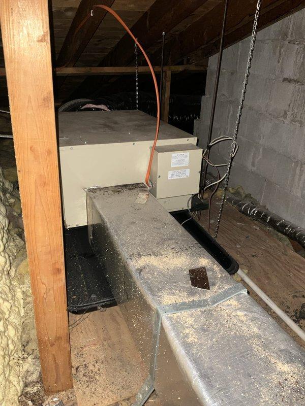 Oconomowoc, WI - Conducted site assessment and documentation for existing Spacepak HVAC system replacement in attic installation. Photographed current air handler unit with associated ductwork, flexible aluminum distribution lines, and existing spray foam and fiberglass insulation configuration. Documented equipment location, structural mounting with chain supports, electrical junction box positioning, and metal duct box connections for preparation of replacement system quote.
