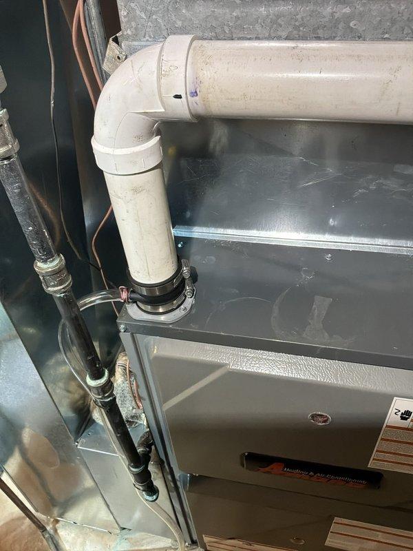 Responded to moisture concern on Daikin gas furnace (Model: AR9T960804CNAA) with water accumulation from PVC condensate venting system in basement. Inspected furnace installation and PVC vent piping connections, confirmed moisture buildup on exterior of vent pipe near furnace connection point. Placed circulating fan on PVC piping to facilitate drying of accumulated condensation. Documented conditions with photographs of furnace, PVC vent connections, and affected areas for monitoring purposes. Homeowner instructed to monitor moisture levels and document any recurring water issues for follow-up assessment.