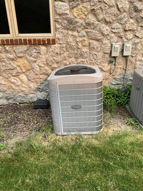 Conducted estimate for replacement of two furnaces and one air conditioning system at a large residential property built in 2006. Homeowner reported inadequate cooling performance on upper level, with thermostat set low but system unable to maintain comfortable temperatures throughout the home. Property currently equipped with two separate AC units—one recently replaced and one original equipment—with one system dedicated to basement zone that maintains adequate cooling but remains largely unused.

Performed on-site inspection of existing HVAC configuration to assess system capacity, zoning arrangement, and potential integration options. Evaluated whether basement cooling system could be reconfigured or supplemented to provide additional cooling capacity to upper levels. Documented outdoor condenser units positioned along exterior wall with electrical disconnect boxes and line sets in place. Photographed existing equipment installation including beige/tan metal housing units with horiz
