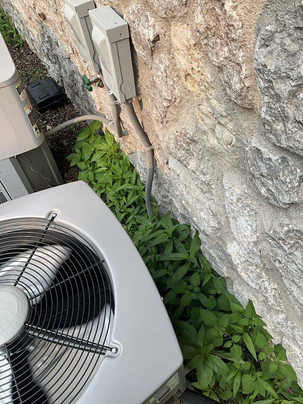 Conducted estimate for replacement of two furnaces and one air conditioning system at a large residential property built in 2006. Homeowner reported inadequate cooling performance on upper level, with thermostat set low but system unable to maintain comfortable temperatures throughout the home. Property currently equipped with two separate AC units—one recently replaced and one original equipment—with one system dedicated to basement zone that maintains adequate cooling but remains largely unused.

Performed on-site inspection of existing HVAC configuration to assess system capacity, zoning arrangement, and potential integration options. Evaluated whether basement cooling system could be reconfigured or supplemented to provide additional cooling capacity to upper levels. Documented outdoor condenser units positioned along exterior wall with electrical disconnect boxes and line sets in place. Photographed existing equipment installation including beige/tan metal housing units with horiz