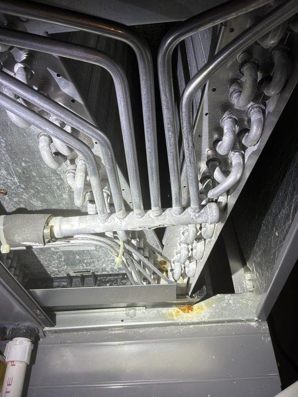 Completed cooling system maintenance check on 2018 ICP air conditioner unit (Model: N4A342AKN300). Upon inspection, discovered extensive ice buildup on evaporator coil and refrigerant lines indicating potential airflow restriction or refrigerant charge issue. Verified equipment specifications, confirmed all manufacturer warranties remain active through 2029, and documented system condition with photographic evidence of frosted coils and electrical panel configuration for further diagnostic evaluation.