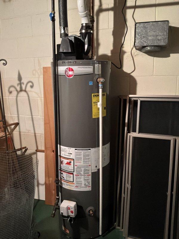 Performed comprehensive ELEC Member Check Up including visual and thermal imaging inspection of electrical system. Documented Rheem Professional water heater installation with proper plumbing connections, expansion tank, and electrical supply. Thermal imaging of electrical panel revealed elevated temperature signatures along central bus bar and circuit breaker connections, indicating potential high-resistance connections or overloaded circuits requiring monitoring or corrective action.
