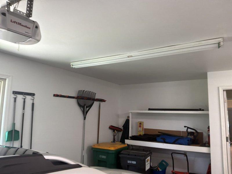 Completed comprehensive electrical member check-up for a 1989 residential property. Performed thorough inspection of main electrical service panel located in basement utility area, evaluating panel condition, wire connections, and cable management entering from ceiling joists. Assessed garage electrical systems including overhead lighting fixture and LiftMaster garage door opener operation to ensure proper functionality and safety compliance.
