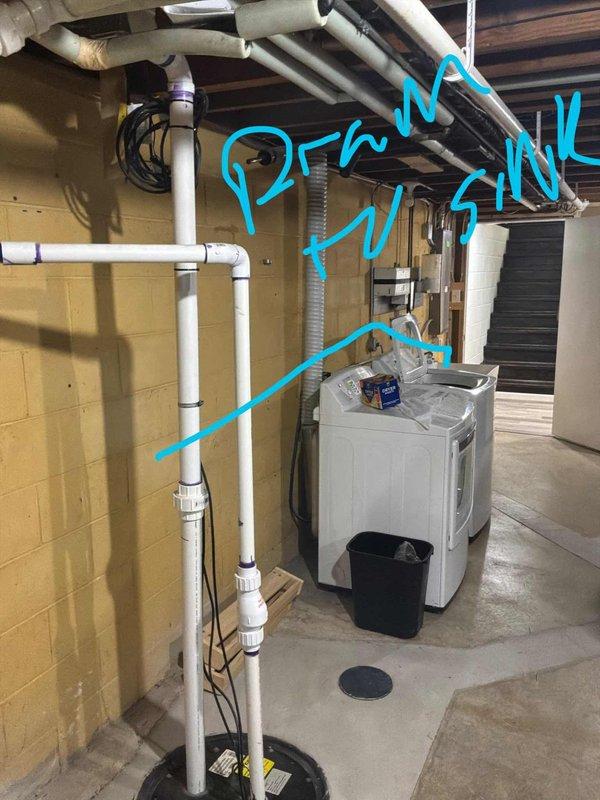 Conducted site assessment for water softener installation and potential iron curtain system in 1959 residential property. Evaluated existing plumbing infrastructure in basement utility area, including white PVC piping configuration along cinder block wall with blue shut-off valve. Documented primary water supply line routing from main to kitchen sink connection point. Assessed installation location near existing laundry facilities and floor drain for proper drainage capability. Discussed future reverse osmosis system integration planned for upcoming kitchen renovation project.