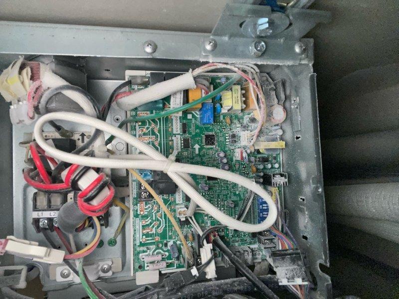 Responded to no cooling complaint on 2-3 year old system where previous contractor was unable to diagnose issue. Located and inspected electrical control panel and circuit board in utility room, verified wiring connections and power supply to outdoor condenser unit. Documented electrical panel configuration with four disconnect switches and conduit routing between outdoor equipment and control board for diagnostic reference.
