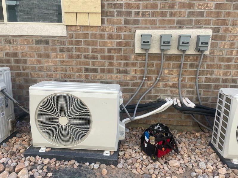 Responded to no cooling complaint on 2-3 year old system where previous contractor was unable to diagnose issue. Located and inspected electrical control panel and circuit board in utility room, verified wiring connections and power supply to outdoor condenser unit. Documented electrical panel configuration with four disconnect switches and conduit routing between outdoor equipment and control board for diagnostic reference.