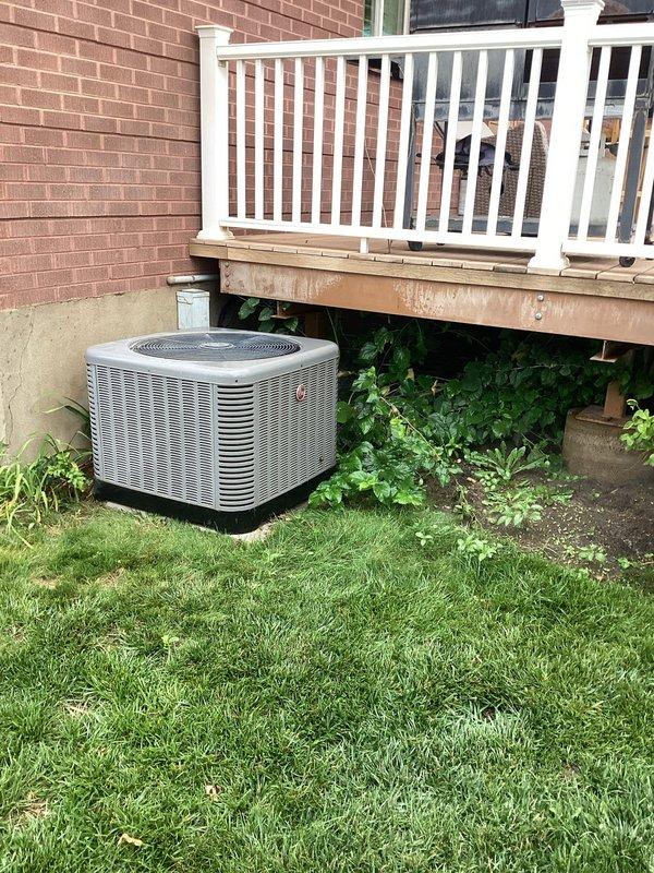 Responded to service call for 4-year-old air conditioning system displaying error codes C and F with unit shutting down after approximately 45 minutes of operation. Performed diagnostic inspection of ground-mounted condenser unit and basement furnace system. Accessed control board compartment and inspected electrical connections, wiring harness, and circuit board for fault conditions. Photographed condenser unit exterior and internal control board assembly showing multiple wire connections and electronic components with visible dust accumulation on metal surfaces and housing.