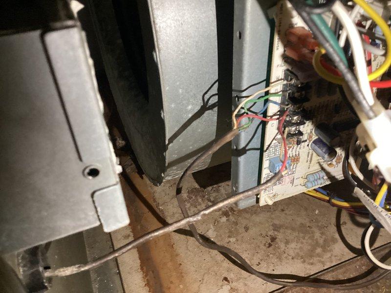 Responded to service call for 4-year-old air conditioning system displaying error codes C and F with unit shutting down after approximately 45 minutes of operation. Performed diagnostic inspection of ground-mounted condenser unit and basement furnace system. Accessed control board compartment and inspected electrical connections, wiring harness, and circuit board for fault conditions. Photographed condenser unit exterior and internal control board assembly showing multiple wire connections and electronic components with visible dust accumulation on metal surfaces and housing.