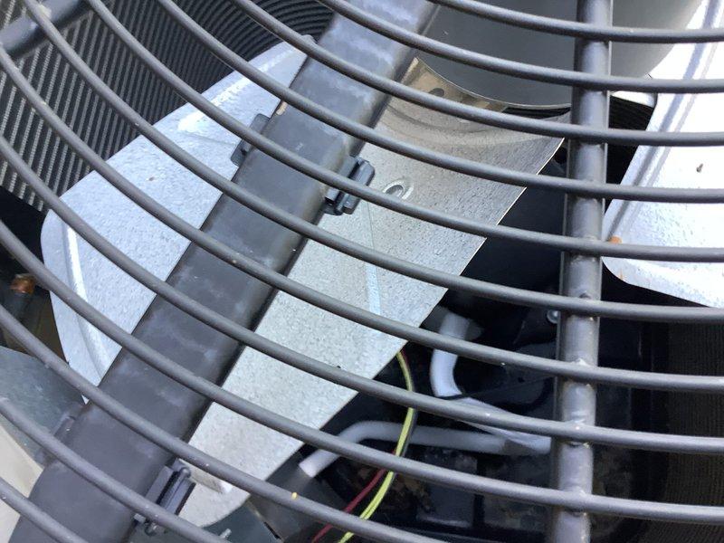 Responded to no cooling complaint on 2018 residential split system air conditioning unit. Upon arrival, performed visual inspection of outdoor condensing unit and verified unit operation. Inspected condenser coil fins through protective fan guard and noted typical outdoor weathering but coils remained in functional condition. Checked refrigerant line insulation and condensate drain line routing from equipment pad across gravel base to ensure proper installation and drainage. Verified electrical connections and wiring integrity at unit. Evaluated overall system operation and identified root cause of insufficient cooling. Completed necessary repairs to restore proper cooling function and verified system returned to normal operating parameters before departure.