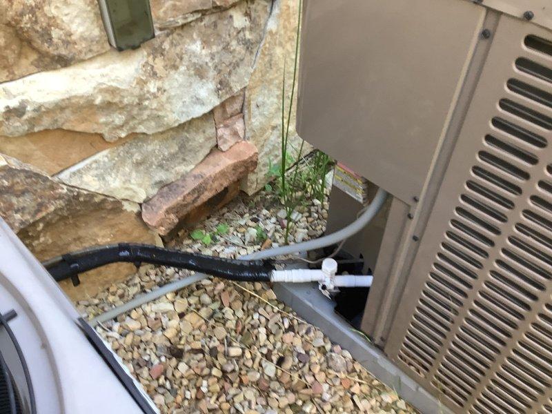 Responded to no cooling complaint on 2018 residential split system air conditioning unit. Upon arrival, performed visual inspection of outdoor condensing unit and verified unit operation. Inspected condenser coil fins through protective fan guard and noted typical outdoor weathering but coils remained in functional condition. Checked refrigerant line insulation and condensate drain line routing from equipment pad across gravel base to ensure proper installation and drainage. Verified electrical connections and wiring integrity at unit. Evaluated overall system operation and identified root cause of insufficient cooling. Completed necessary repairs to restore proper cooling function and verified system returned to normal operating parameters before departure.