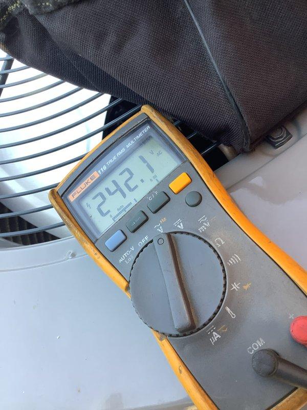 Completed preventive maintenance inspection on 2-year-old residential air conditioning unit located at side of garage. Performed standard tune-up procedures including voltage verification using digital multimeter, which confirmed proper electrical supply at 242.1 volts. Inspected outdoor condenser unit, compressor, electrical connections, and cooling fan operation. Unit equipped with washable filters, which were noted for homeowner maintenance. No reported issues or deficiencies found during inspection; system operating within normal parameters.