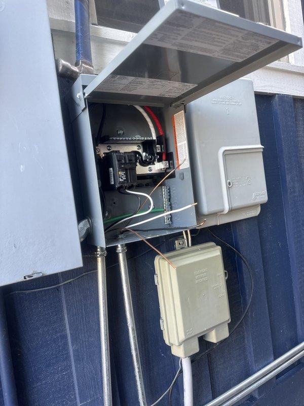 Completed full HVAC system installation including two CK40CT-18/24 condensing units (A and B configurations), ML13CK1-018 air handler, and PRO1 T705 programmable thermostat. Installed exterior electrical disconnect boxes with weather-protective canopy, proper conduit runs, and grounding connections on building exterior per code requirements. All electrical components properly mounted, wired, and tested for system functionality.