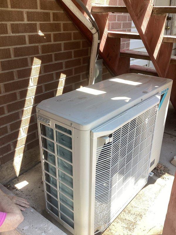 Responded to service call for 3-year-old residential air conditioning system experiencing pressure error and non-operational condenser fan. Upon arrival, coordinated entry timing to accommodate household pets and worked carefully around customer's medical oxygen equipment. Inspected outdoor condenser unit located in backyard against brick wall and indoor Daikin air handler positioned in basement mechanical space. Evaluated system performance, checked refrigerant pressures, and assessed condenser fan motor operation. Documented equipment condition through photographic records showing both outdoor and indoor HVAC components. Verified proper drainage system function including PVC condensate lines and flexible discharge hose. Completed diagnostic assessment of reported pressure fault and fan failure on residential split system.