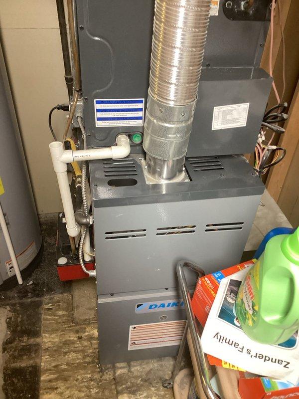 Responded to service call for 3-year-old residential air conditioning system experiencing pressure error and non-operational condenser fan. Upon arrival, coordinated entry timing to accommodate household pets and worked carefully around customer's medical oxygen equipment. Inspected outdoor condenser unit located in backyard against brick wall and indoor Daikin air handler positioned in basement mechanical space. Evaluated system performance, checked refrigerant pressures, and assessed condenser fan motor operation. Documented equipment condition through photographic records showing both outdoor and indoor HVAC components. Verified proper drainage system function including PVC condensate lines and flexible discharge hose. Completed diagnostic assessment of reported pressure fault and fan failure on residential split system.