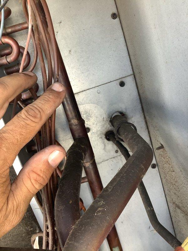 Responded to service call for two rooftop HVAC units blowing warm air at commercial facility. Accessed Daikin rooftop package unit and identified refrigerant leak at brazed copper connections, evidenced by significant oxidation and discoloration at joints. Leak resulted in low refrigerant charge causing loss of cooling capacity. Repaired leak, pressure tested system, evacuated lines, and recharged unit to manufacturer specifications. Verified proper operation and adequate cooling restored to affected zones.