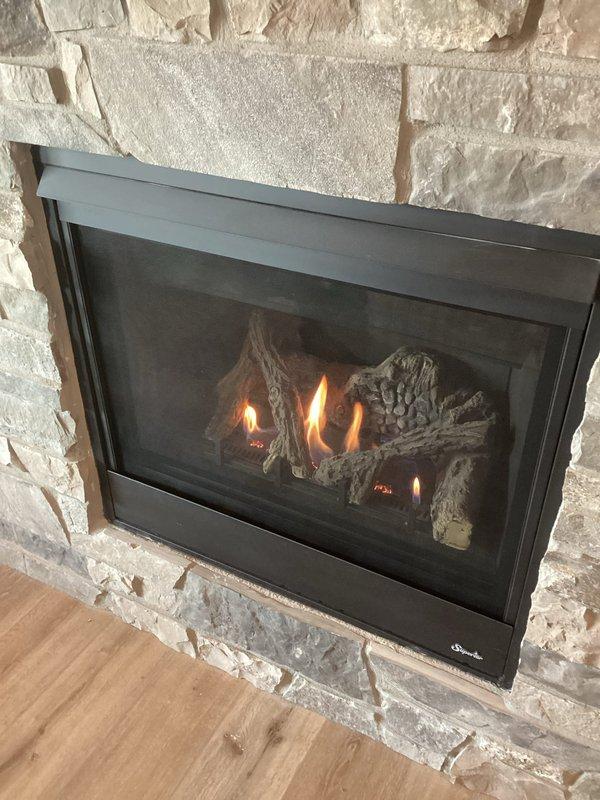 Responded to service call for gas fireplace maintenance with reported pilot light issue. Performed comprehensive inspection of gas fireplace insert installed in stone surround, including examination of pilot assembly, thermocouple, gas valve, and burner system. Verified proper ignition sequence, flame pattern, and operational functionality of all fireplace components. Unit tested and confirmed operating safely with appropriate blue and orange flame characteristics across ceramic log set.