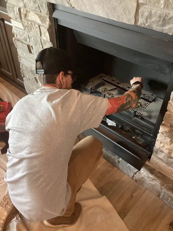 Responded to service call for gas fireplace maintenance with reported pilot light issue. Performed comprehensive inspection of gas fireplace insert installed in stone surround, including examination of pilot assembly, thermocouple, gas valve, and burner system. Verified proper ignition sequence, flame pattern, and operational functionality of all fireplace components. Unit tested and confirmed operating safely with appropriate blue and orange flame characteristics across ceramic log set.