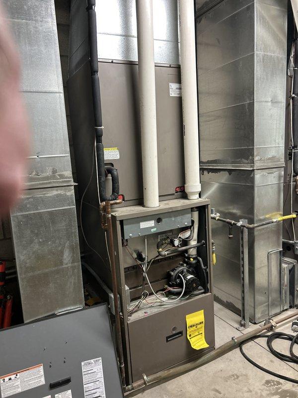 Performed comprehensive assessment of 18-year-old 5-ton commercial HVAC system experiencing complete failure. Unit found to be non-operational with severely deteriorated condenser coil fins showing extensive corrosion throughout. Documented electrical panel configuration and existing furnace installation with associated ductwork and venting systems. Provided estimate for complete system replacement due to age of equipment and extent of component degradation making repair economically unfeasible.