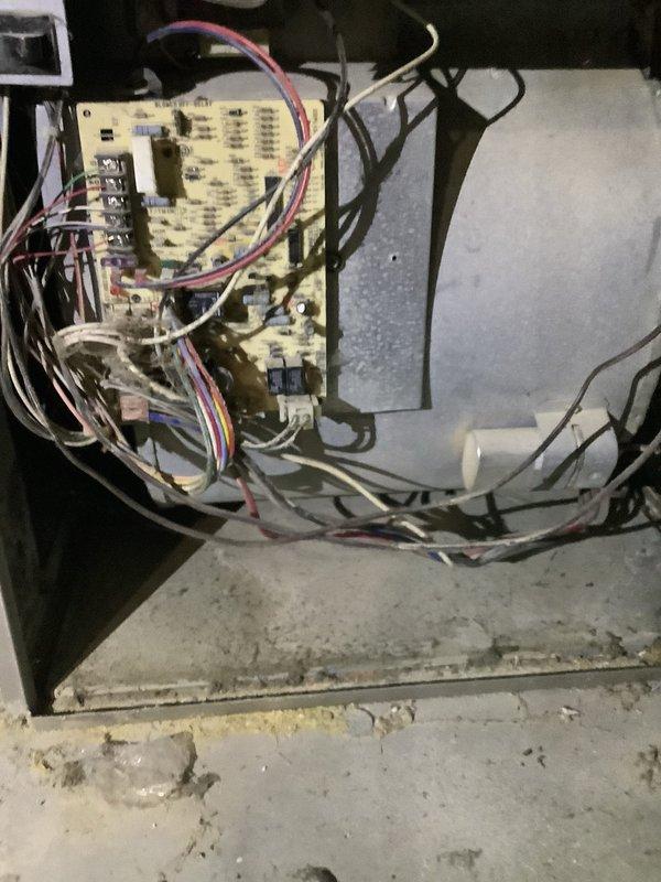 Responded to service call for air conditioning system experiencing reduced cooling capacity with 7-degree temperature differential at thermostat. Performed diagnostic inspection of 5-9 year old split system with outdoor condensing unit located at side of property and furnace in basement utility area. Inspected control board and electrical connections, documenting accumulated debris and dust in furnace compartment and on exterior cabinet panels requiring attention for optimal system performance.