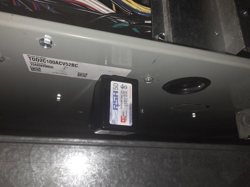 Installed warranty blower assembly with personality module on HVAC unit model TDD2G100ACV52BC. Installed two surge protectors to provide electrical protection for the system. All components tested and verified operational with indicator lights confirming proper function.