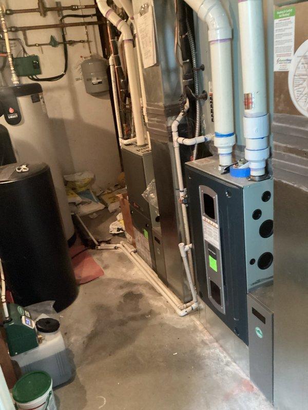 Completed annual heating maintenance service as part of the Comfort Care maintenance plan. Performed comprehensive furnace tune-up and inspection of all HVAC equipment in basement mechanical room, including blue/gray furnace unit with PVC venting system and beige air handler. Conducted temperature differential measurements using infrared thermometer, recording supply air temperature readings to verify proper system operation. Inspected all associated components including ductwork, copper piping, expansion tank, and electrical connections. System operating within normal parameters upon completion of maintenance service.