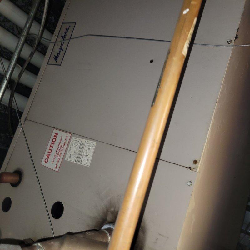 Responded to commercial facility reporting one of three ceiling-mounted AC units not producing cold air. Upon arrival, accessed approximately 20-year-old air handler unit installed in ceiling space above business location. Performed comprehensive Cool 10+ preventive maintenance inspection on the affected system. Examined air handler cabinet, refrigerant lines, and associated components in confined ceiling installation area. Inspected copper refrigerant piping, electrical connections, and control systems. Verified proper operation of all mechanical components and assessed overall system condition given age of equipment. Documented existing installation configuration with multiple copper lines running through structural framing. System evaluated for cooling performance and operational efficiency to address reported lack of cold air output.