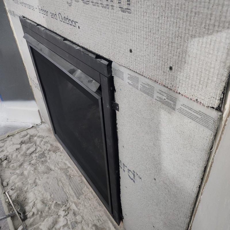 Responded to possible recall for unit BX36NTRE, PRPB36 with code 7449#. Inspected and documented installation of cement board material and ventilation components on exterior wall assembly. Verified proper mounting of dark-framed vent opening with mesh screen and confirmed cement board installation with visible fastener points and mesh reinforcement at seams. Photographed completed work showing building envelope system in construction phase for warranty and recall documentation purposes.