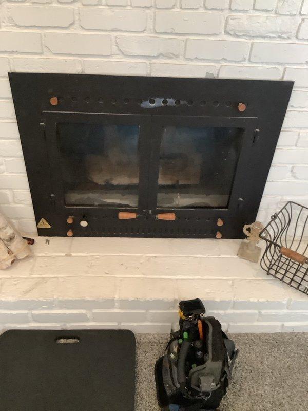 Performed comprehensive inspection and diagnostic evaluation of 1984 Alpine gas fireplace insert with black metal frame and glass doors. Assessed blower motor assembly for operational functionality and conducted thorough examination of gas line connections and venting system in crawl space beneath unit. Documented current condition of fireplace components including sooted glass doors, metallic control elements, and overall system performance. Provided technical assessment and recommendations for repair of existing unit, along with consultation regarding feasibility and requirements for installing a new direct vent fireplace system in an additional room without existing fireplace infrastructure.