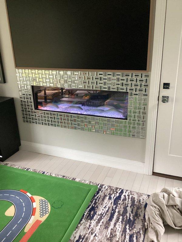 Responded to service call for Heat & Glo gas fireplace unit that would not stay lit. Customer reported lost remote control which was preventing proper operation of the system. Assessed wall-mounted fireplace installation with decorative tile surround and determined replacement remote would be necessary for continued functionality and normal operation of the unit.