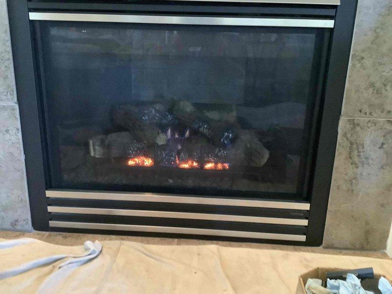 Performed comprehensive maintenance inspection on 20-year-old electric fireplace insert with artificial log set and LED flame effect system. Unit was found to be operating properly with no reported issues; verified all heating elements, lighting components, and safety features functioning as designed. Documented fireplace condition with photographs for service records.