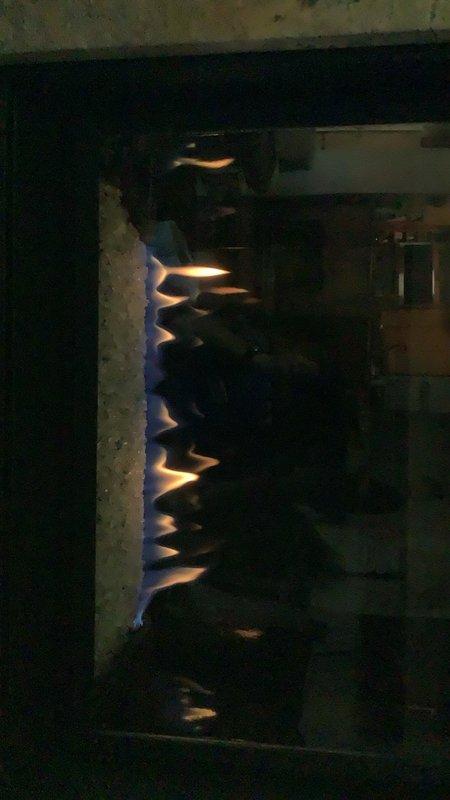Installed replacement pilot assembly on gas fireplace and completed system tune-up. Verified proper flame pattern and combustion characteristics, with burner now displaying correct blue flame with orange tips. Unit tested and confirmed operational with all safety systems functioning properly.
