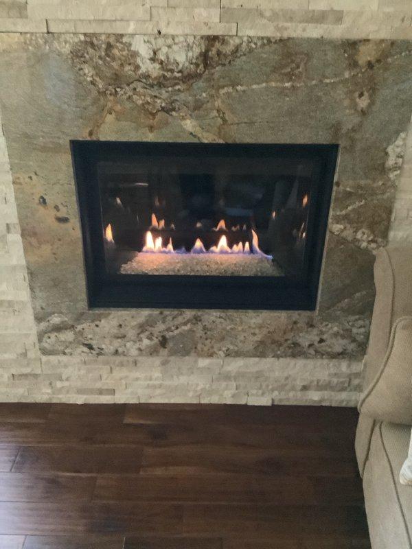 Installed replacement pilot assembly on gas fireplace and completed system tune-up. Verified proper flame pattern and combustion characteristics, with burner now displaying correct blue flame with orange tips. Unit tested and confirmed operational with all safety systems functioning properly.