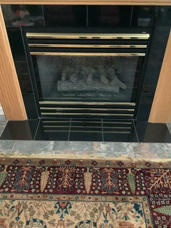Installed fireplace blower kit on gas fireplace insert with decorative ceramic log set and glass front. Completed system makeover, ensuring proper ventilation through existing louvers and verifying blower operation with heat distribution system. Unit tested and confirmed operational with all components functioning as designed.